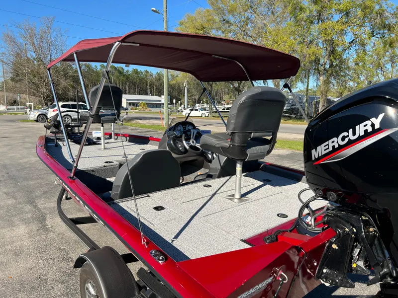 Slide: The Image of 2022 Bass Tracker Pro Team 175 boat with Mercury engine and canopy, parked outdoors. - 10