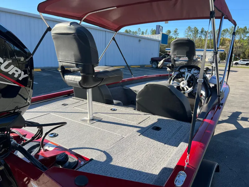Slide: The Image of 2022 Bass Tracker Pro Team 175 boat with canopy and seating, parked outdoors. - 17