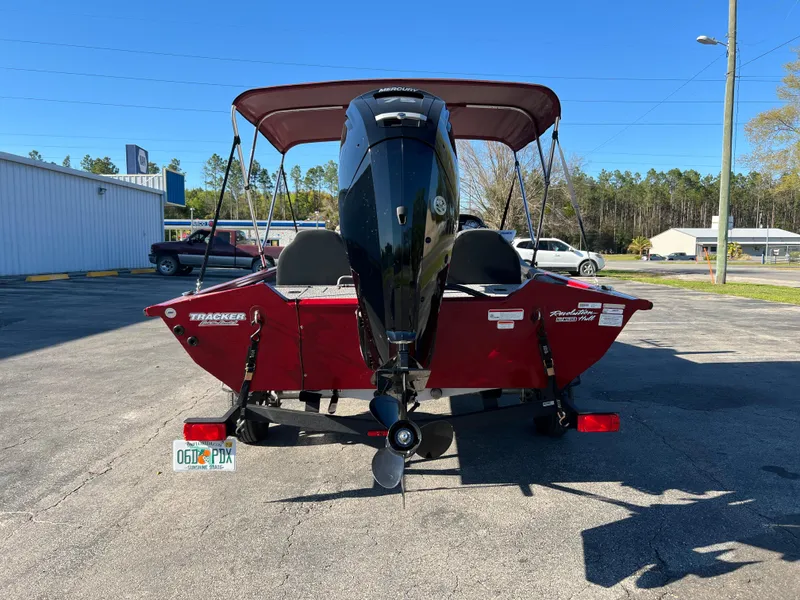 Slide: The Image of 2022 Bass Tracker Pro Team 175 boat, red, parked outdoors with canopy and motor visible. - 7