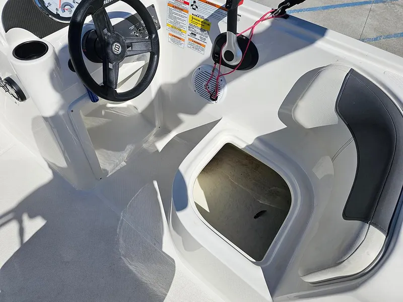 Slide: The Image of 2021 Bayliner Element E18 boat interior with steering wheel and seating area. - 18