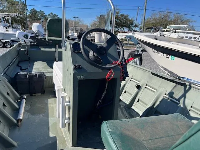 Slide: The Image of 2011 Southfork 16CC boat interior with steering console and seating, parked in a marina. - 6
