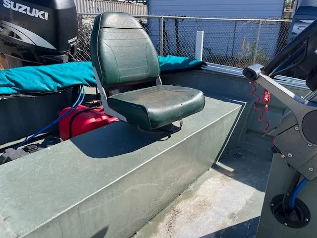 Slide: The Image of 2011 Southfork 16CC boat interior with green seat and Suzuki outboard motor. - 8