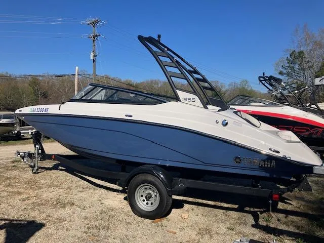 Slide: The Image of 2024 Yamaha Boats 195S on trailer, blue and white design, parked outdoors. - 2