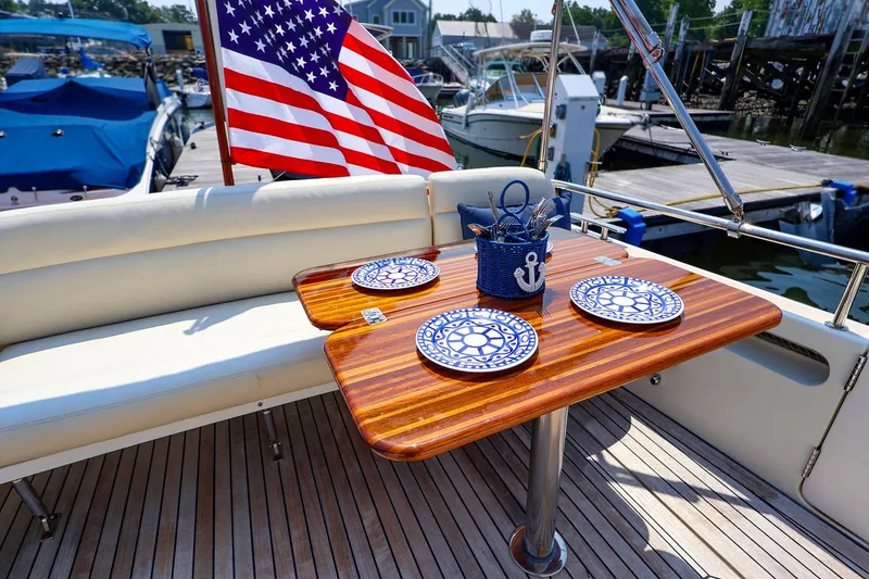 Slide: The Image of Elegant dining setup on 2010 MJM 40z Downeast yacht with nautical-themed plates and American flag. - 34