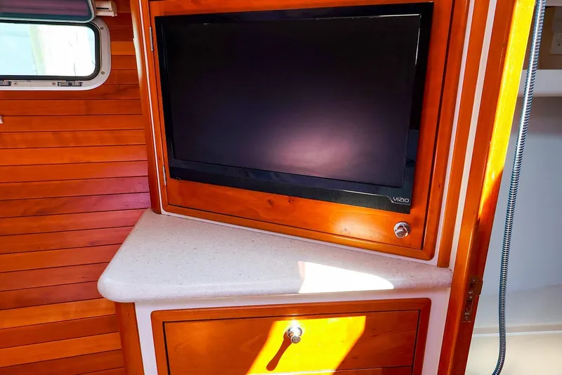Slide: The Image of 2010 MJM 40z Downeast interior with mounted Vizio TV and wooden cabinetry. - 48