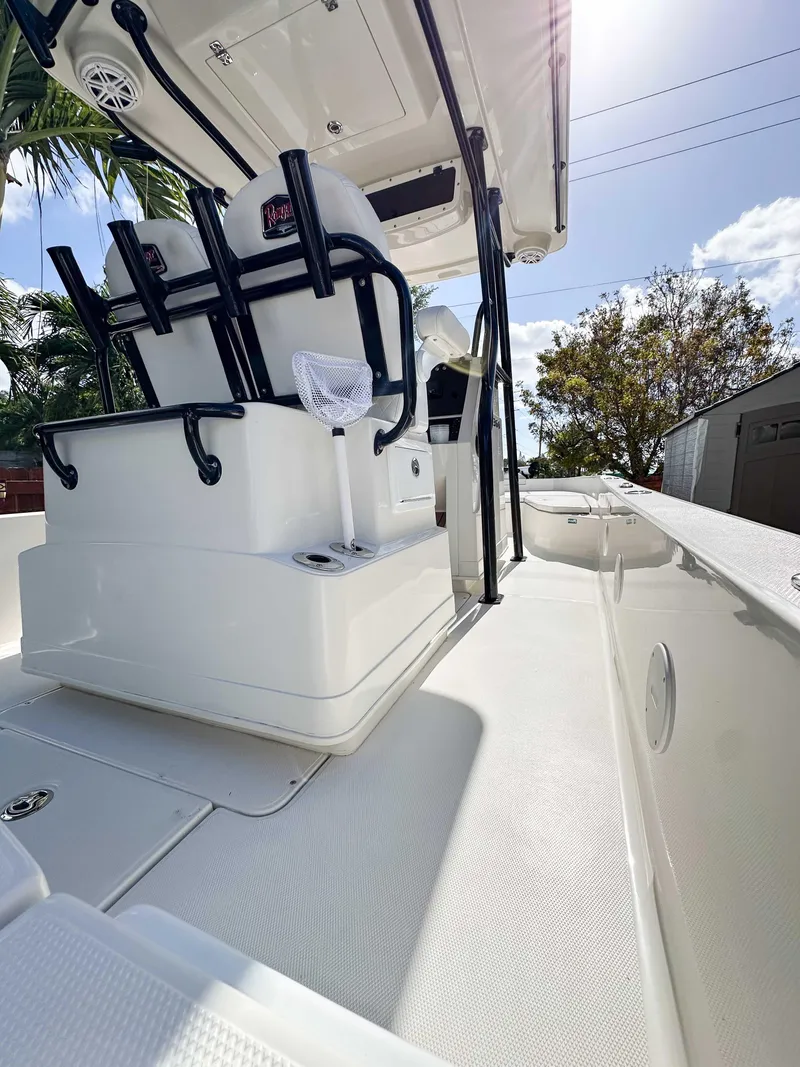 Slide: The Image of 2023 Ranger 2360 Bay boat interior with seating and console, under clear sky. - 10