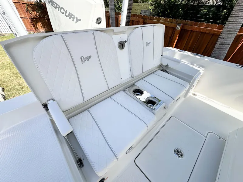 Slide: The Image of 2023 Ranger 2360 Bay boat with white cushioned seating and cup holders. - 15