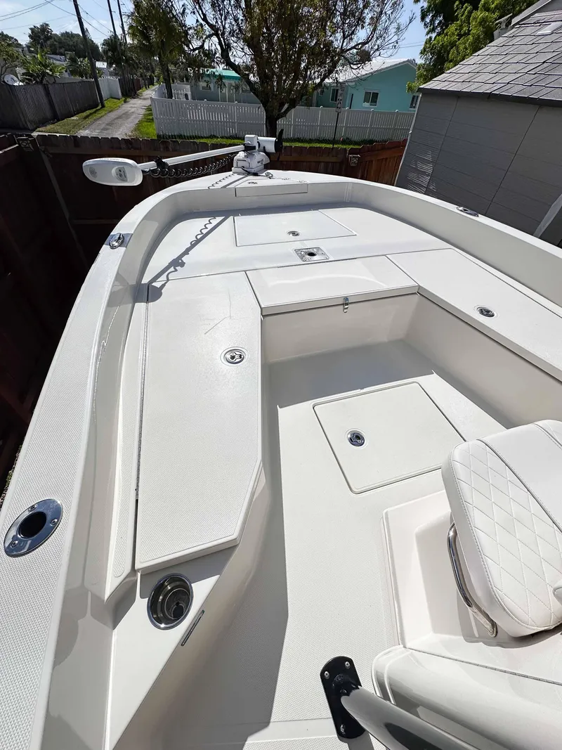Slide: The Image of 2023 Ranger 2360 Bay boat with spacious deck and seating, docked outdoors. - 16