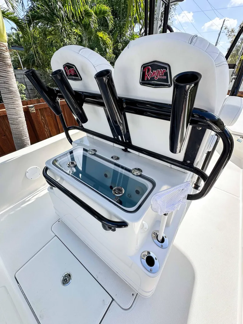 Slide: The Image of 2023 Ranger 2360 Bay boat with rod holders and seating, set against a tropical backdrop. - 18