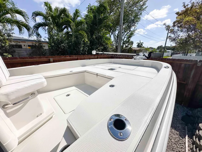 Slide: The Image of 2023 Ranger 2360 Bay boat with spacious deck, surrounded by lush greenery and clear skies. - 21