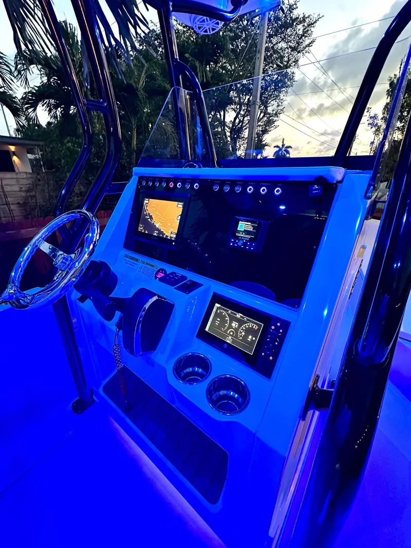Slide: The Image of 2023 Ranger 2360 Bay boat console with illuminated controls and navigation screens at dusk. - 26
