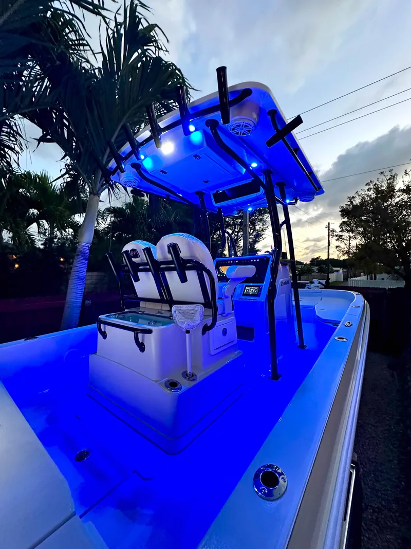 Slide: The Image of 2023 Ranger 2360 Bay boat with blue LED lights, palm trees in background. - 27