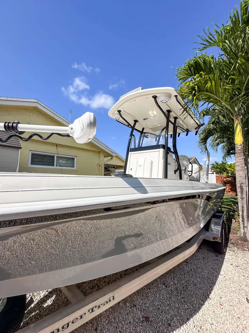 Slide: The Image of 2023 Ranger 2360 Bay boat parked outdoors under clear blue sky. - 3