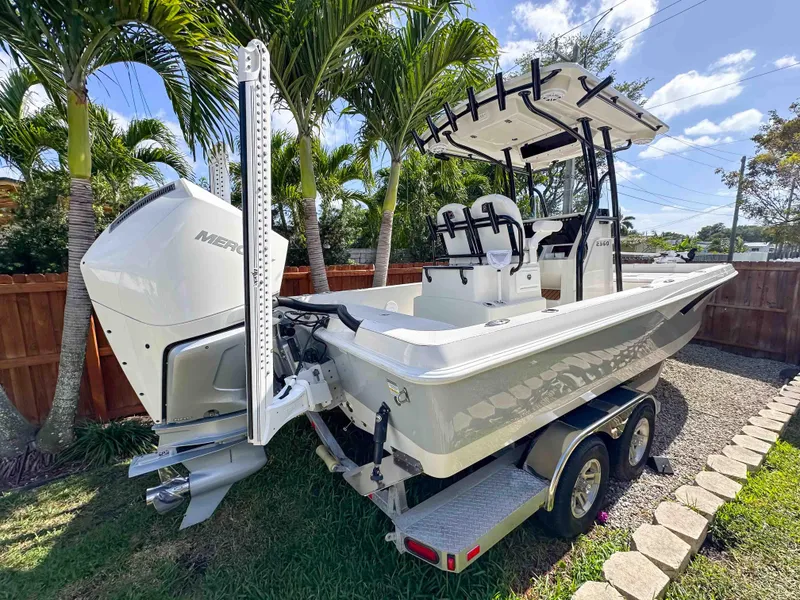 Slide: The Image of 2023 Ranger 2360 Bay boat on trailer, parked outdoors with palm trees in background. - 5
