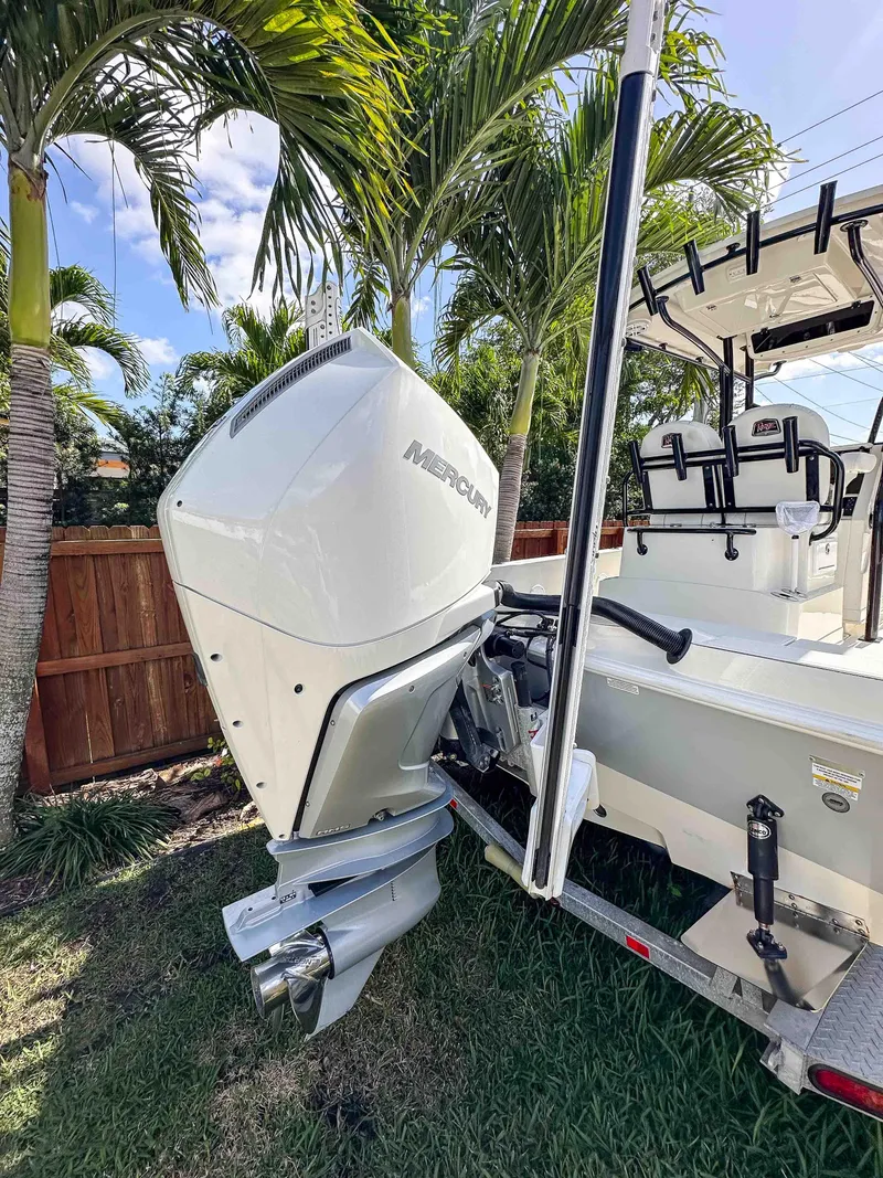 Slide: The Image of 2023 Ranger 2360 Bay boat with Mercury outboard motor, parked near palm trees. - 7