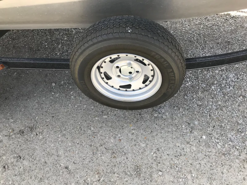 Slide: The Image of 2012 Tracker Pro Team 175 TF trailer wheel on gravel surface. - 19