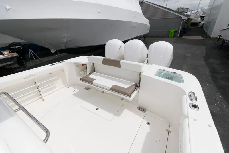 Slide: The Image of 2017 Edgewater 368CC boat with triple engines and foldable seating in a marina setting. - 10