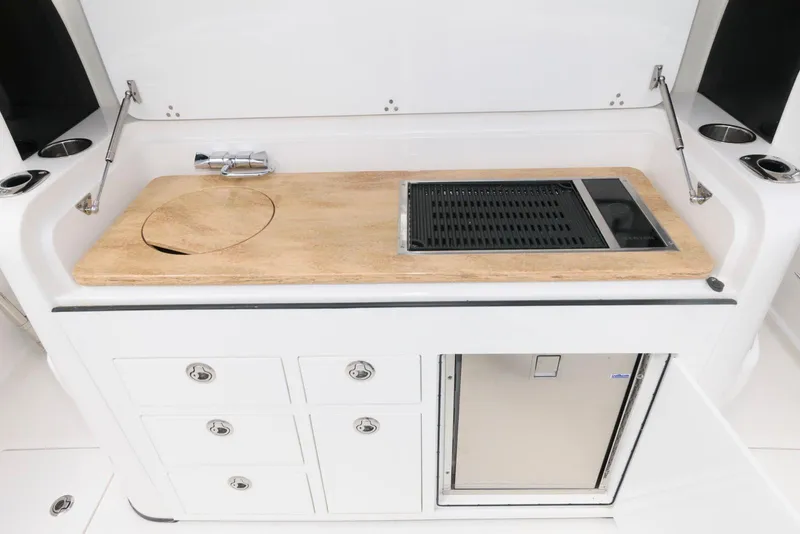 Slide: The Image of 2017 Edgewater 368CC boat kitchen with sink, grill, and storage drawers. - 14
