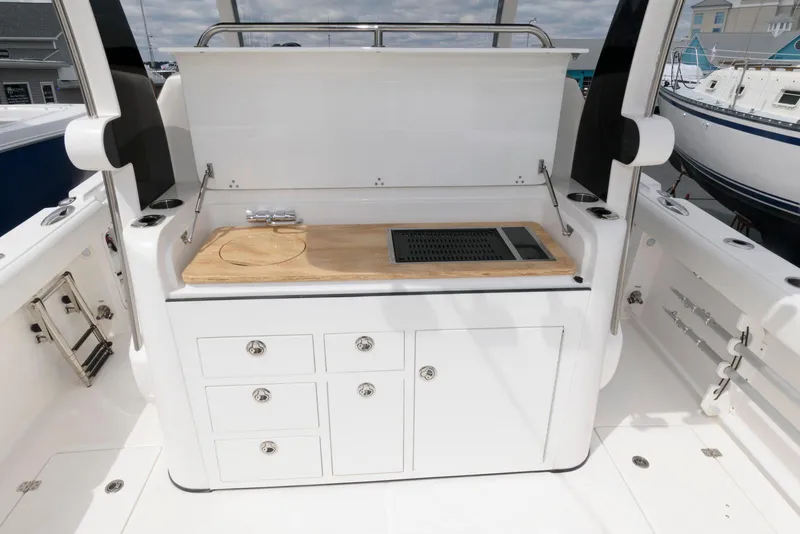 Slide: The Image of 2017 Edgewater 368CC boat with a sleek outdoor kitchen and storage cabinets. - 15