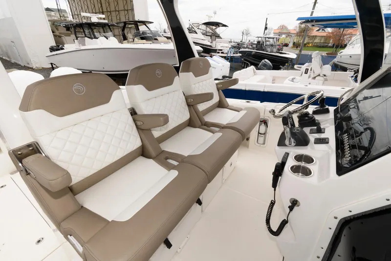 Slide: The Image of 2017 Edgewater 368CC boat interior with beige and white seating, helm, and controls. - 17