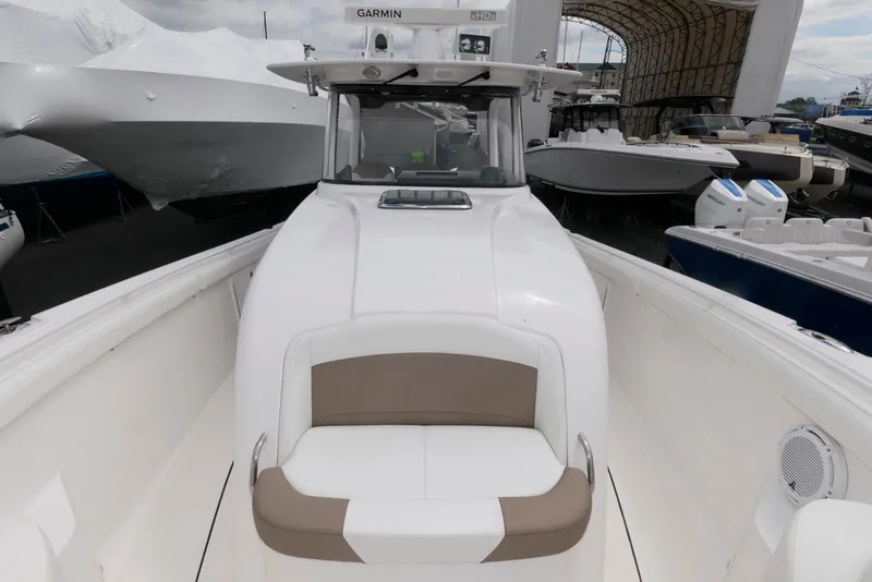 Slide: The Image of 2017 Edgewater 368CC boat with white and beige seating, docked among other vessels. - 21