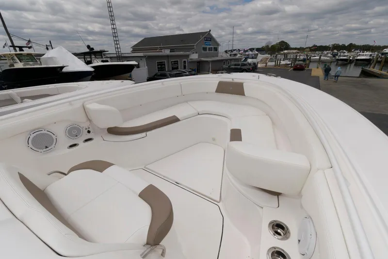 Slide: The Image of 2017 Edgewater 368CC boat with spacious white seating and modern design at a marina. - 22