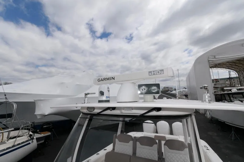 Slide: The Image of 2017 Edgewater 368CC boat with Garmin radar, docked under cloudy sky. - 25