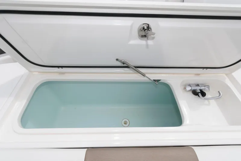 Slide: The Image of Open storage compartment on 2017 Edgewater 368CC boat, featuring a built-in faucet. - 29