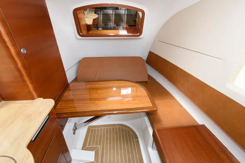 Slide: The Image of 2017 Edgewater 368CC cabin interior with wooden table, seating, and mirror. - 31