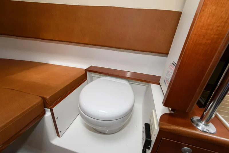 Slide: The Image of 2017 Edgewater 368CC boat interior with compact marine toilet and seating area. - 35