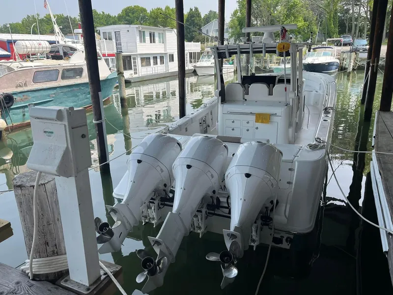 Slide: The Image of 2017 Edgewater 368CC boat docked with triple outboard engines in a marina. - 6