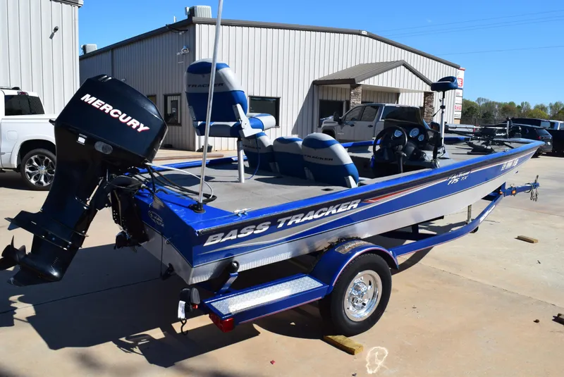 Slide: The Image of 2006 Tracker Pro Team 175 TX boat with Mercury engine, parked outside a building. - 2