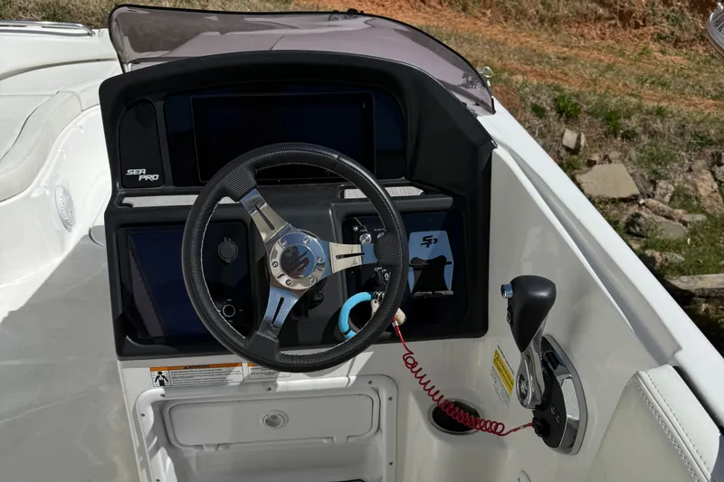 Slide: The Image of 2022 Sea Pro 2400 SC DECK boat helm with steering wheel and controls. - 4