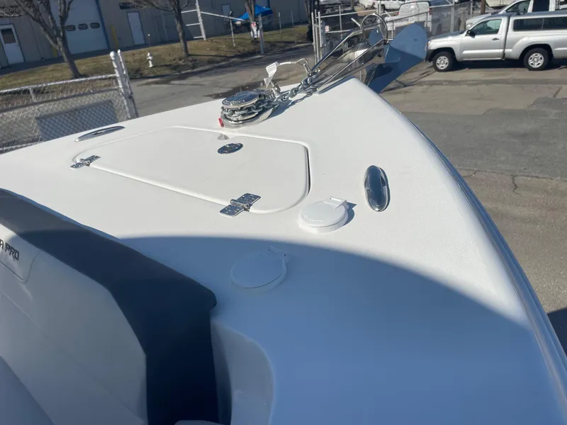 Slide: The Image of 2025 Sea Pro 225 Sandbar boat bow with anchor and hatch, parked outdoors. - 13