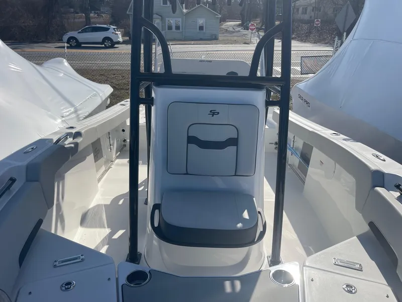 Slide: The Image of 2025 Sea Pro 225 Sandbar boat interior with seating and console, docked outdoors. - 15