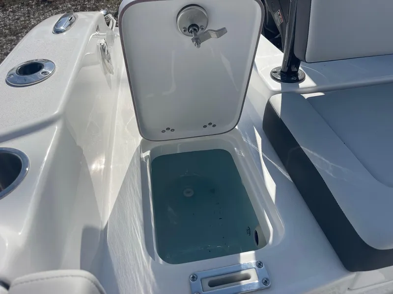 Slide: The Image of 2025 Sea Pro 225 Sandbar boat with open storage compartment and cup holders. - 16