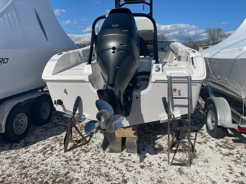Slide: The Image of 2025 Sea Pro 225 Sandbar boat with outboard motor, parked on a trailer. - 2