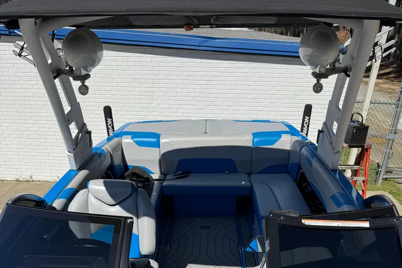 Slide: The Image of 2019 Malibu Wakesetter 23 LSV interior with blue and gray seating, speakers, and wakeboard racks. - 11