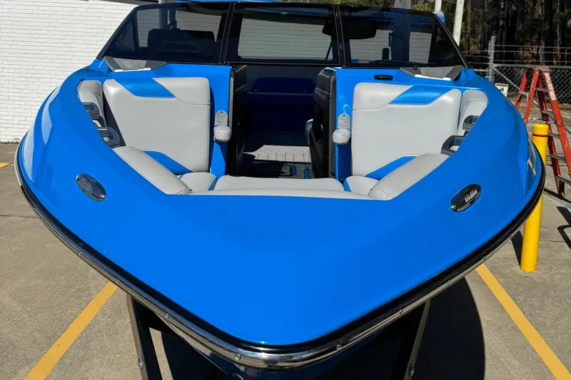 Slide: The Image of 2019 Malibu Wakesetter 23 LSV boat with blue and gray seating, parked outdoors. - 4