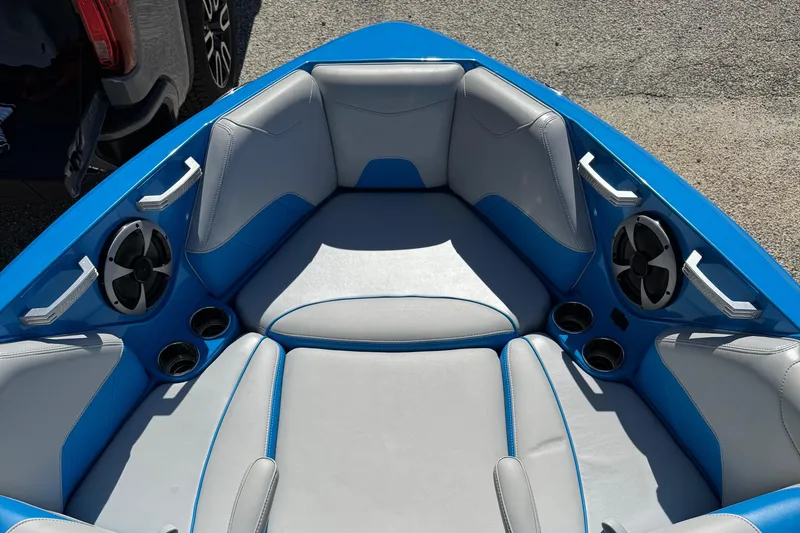 Slide: The Image of 2019 Malibu Wakesetter 23 LSV boat interior with blue and gray seating, cup holders, and speakers. - 7