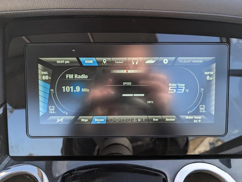 Slide: The Image of Dashboard display of a 2019 Yamaha Boats 242 Limited S showing FM radio and water temperature. - 23