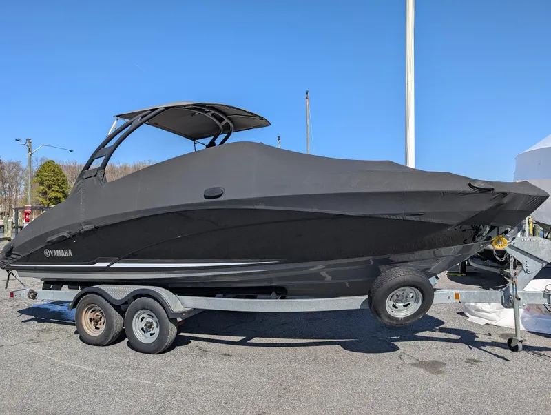 Slide: The Image of 2019 Yamaha Boats 242 Limited S covered on a trailer, parked outdoors. - 28