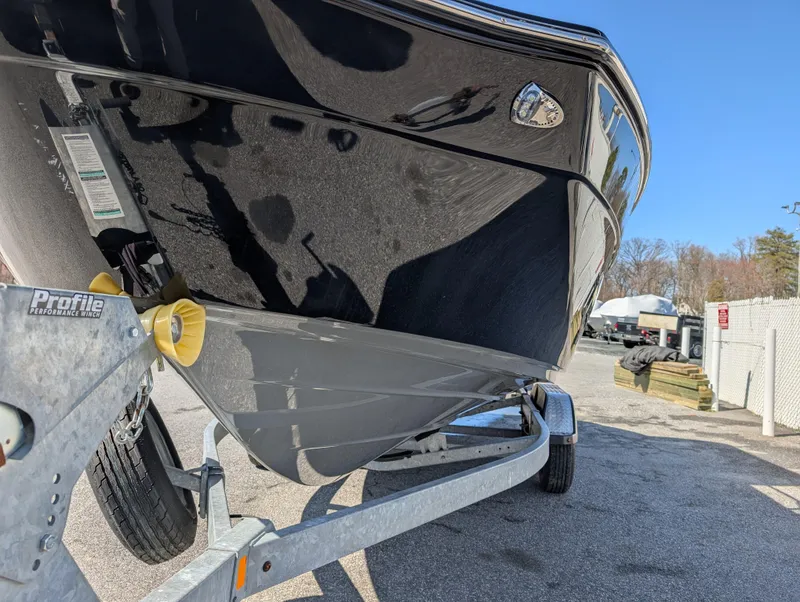 Slide: The Image of 2019 Yamaha Boats 242 Limited S on trailer, showcasing sleek black hull design. - 6