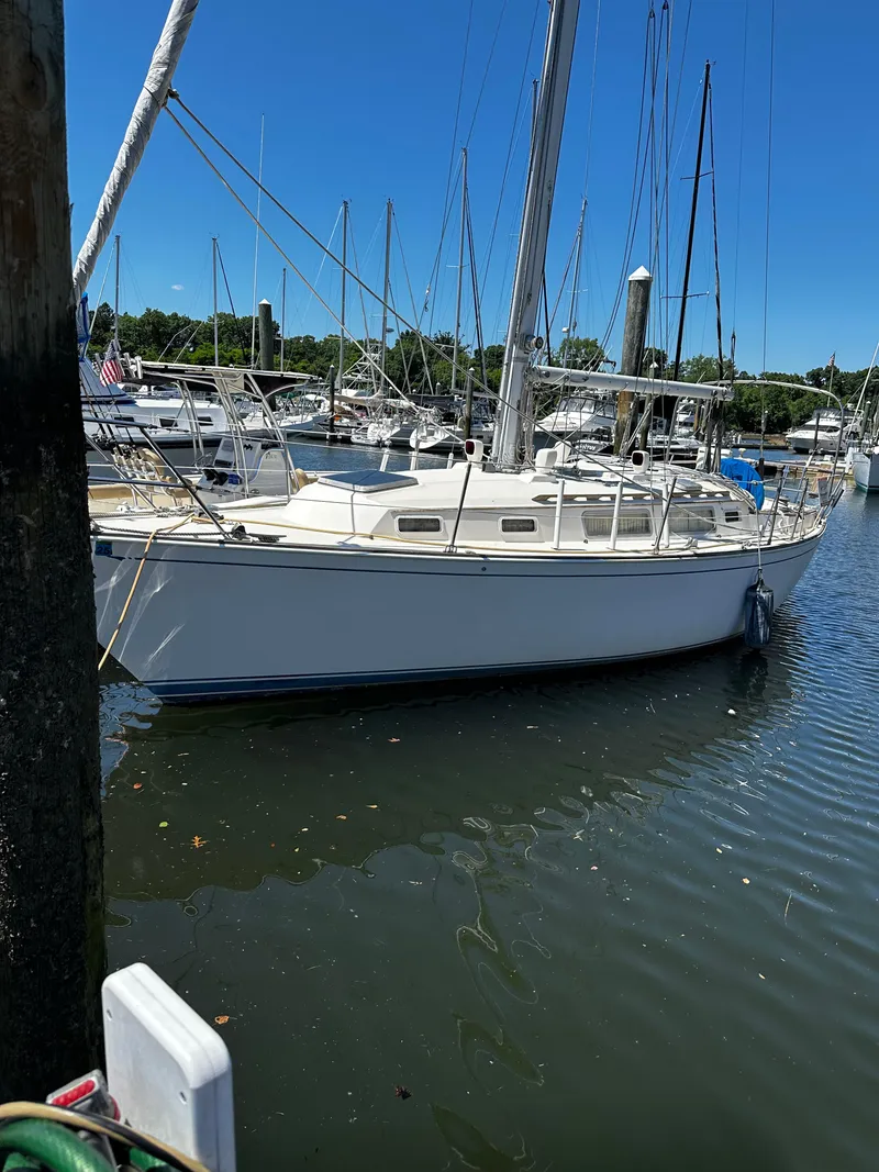 Slide: The Image of 1985 Sabre 32 Aft Cabin sailboat docked in a marina under clear blue skies. - 20