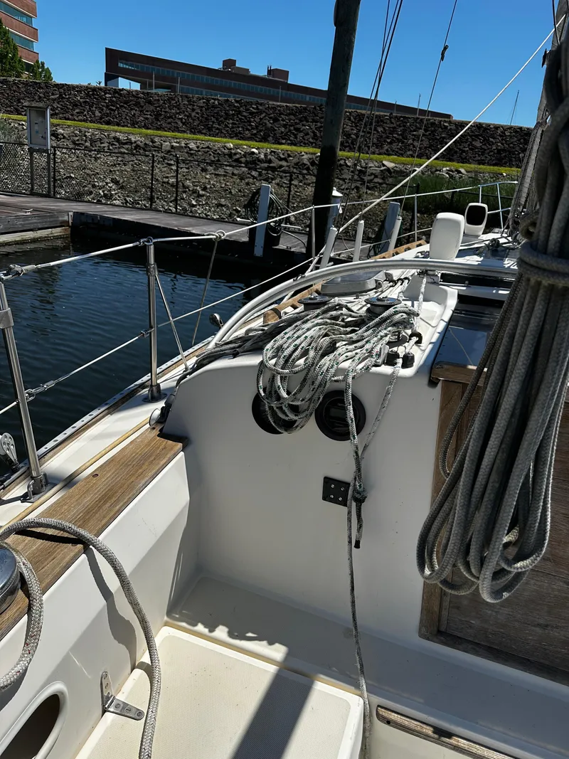 Slide: The Image of 1985 Sabre 32 Aft Cabin sailboat docked, featuring deck ropes and railing. - 7