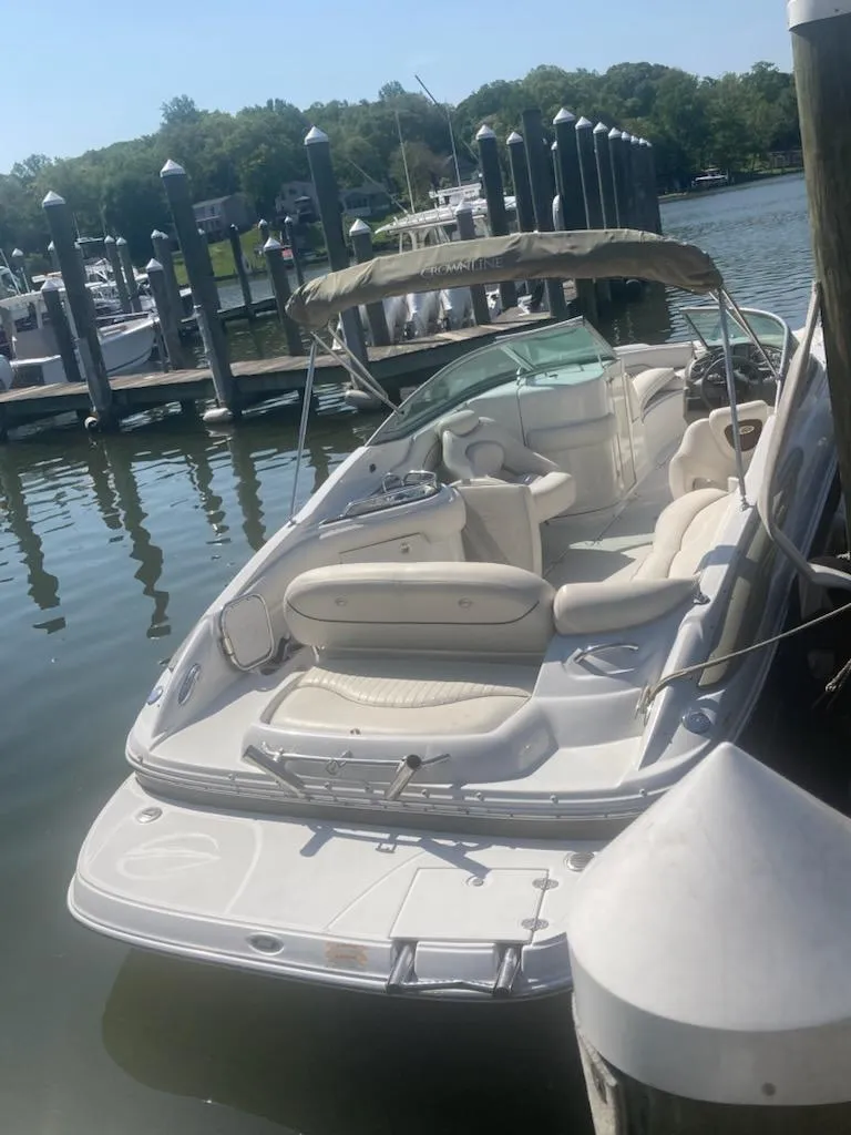 Slide: The Image of 2006 Crownline 262 EX boat docked at marina, featuring spacious seating and canopy. - 4