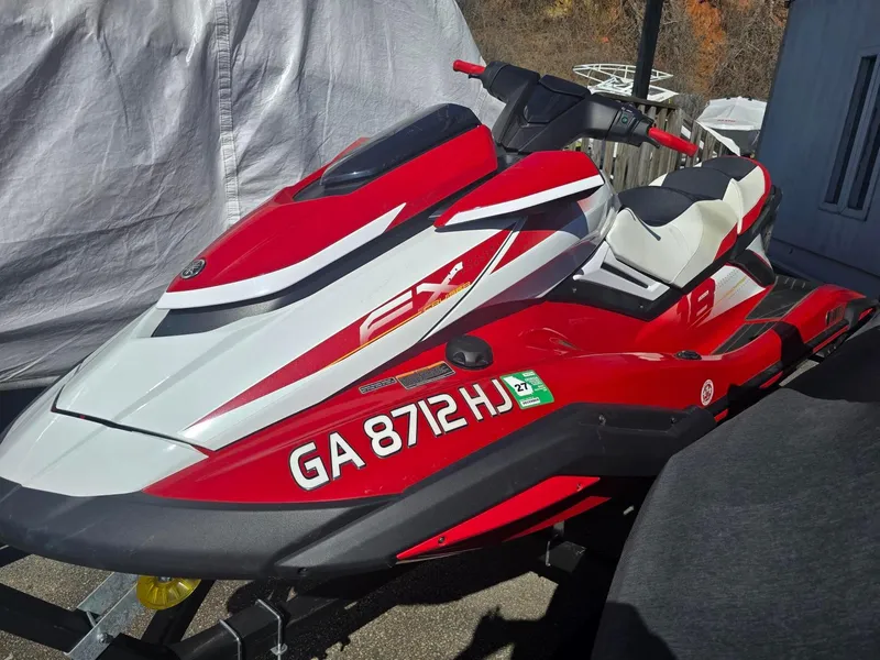Slide: The Image of 2021 Yamaha WaveRunner FX Cruiser SVHO in red and white, parked outdoors. - 0