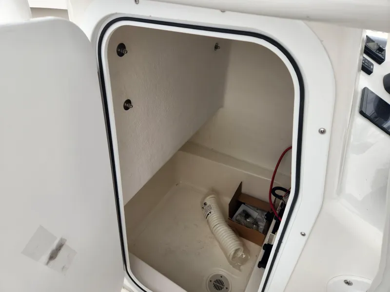 Slide: The Image of 2025 May-Craft 245 Offshore CC storage compartment with open door, showcasing interior space. - 13