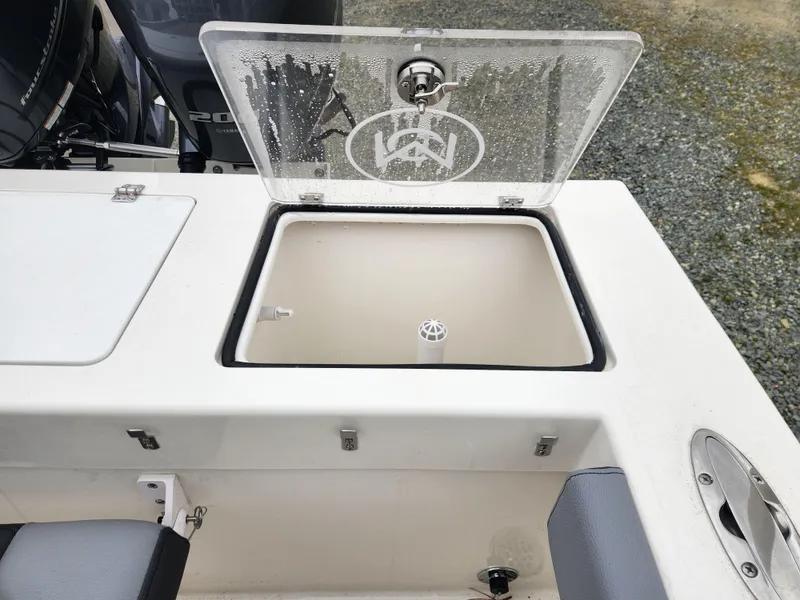 Slide: The Image of 2025 May-Craft 245 Offshore CC boat with open storage compartment and visible engine. - 17