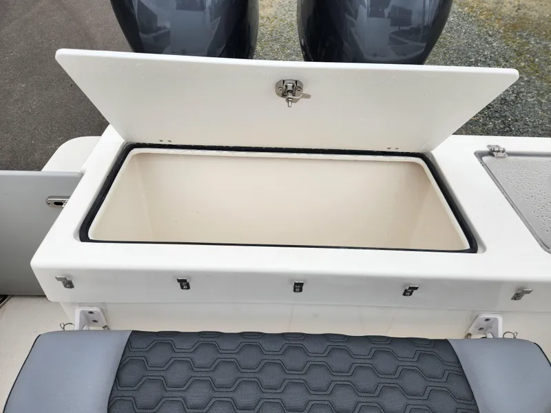 Slide: The Image of 2025 May-Craft 245 Offshore CC boat with open storage compartment and dual engines. - 18